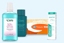 Een selectie van verzorgingsproducten, waaronder Care Sensitive mondwater, Care Energaboost douchegel, een doos Albert Heijn tissues en Elmex Sensitive tandpasta.