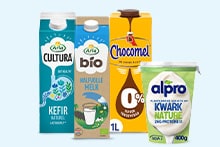 Verschillende zuivelproducten, waaronder Campina kefir, Campina biologische melk, Chocomel 0%, en Alpro kwark natuur, naast elkaar op een lichte achtergrond.