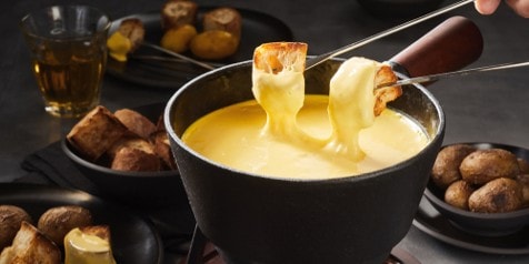 Kaasfondue met stukken brood en aardappelen