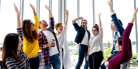 Groep mensen die hun handen opsteken in een lichte kantoorruimte.