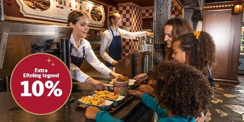 Mensen ontvangen bakjes friet bij een snackbar in Efteling, met een ronde sticker waarop staat "Extra Efteling tegoed 10%".