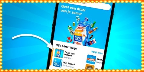 Afbeelding van een smartphone waarop de Albert Heijn-app openstaat, met een promotie op het scherm voor de zomeractie "Geef een draai aan je zomer" en verschillende producten, omringd door gele lampjes.