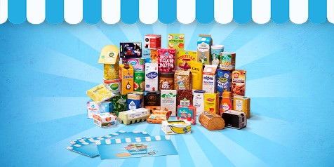 Assortiment van diverse A-merken en huismerkproducten van Albert Heijn, zoals Nutella, Alpro, Activia en ontbijtproducten, uitgestald voor een blauwe achtergrond met winkelthema