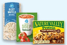 Drie producten: een pak AH rijstwafels naturel, een blik AH tomatensoep en een doos Nature Valley Protein repen pinda en chocolade.