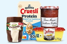 Verschillende ontbijtproducten waaronder Quaker Cruesli Protein Kokos & Vanille, Duo Penotti chocolade- en vanillepasta, Bonne Maman aardbeienconfituur en Johma eiersalade.
