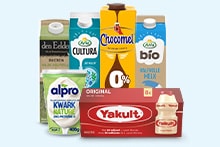 Assortiment van zuivelproducten en alternatieven, waaronder Chocomel, Yakult, Alpro en biologische melk, gepresenteerd op een lichte achtergrond.