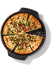 Vegetarische quiche met granaatappelpitjes en kruiden in een bakvorm.