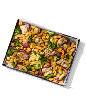 Bakplaat met gebakken kipfilet, groenten zoals broccoli en rode ui, en blokjes zoete aardappel.
