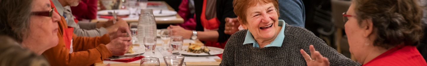 Mensen genieten van een maaltijd aan een tafel in een sociale setting.