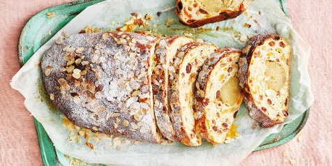 Gesneden stol met rozijnen en amandelen op een groen dienblad