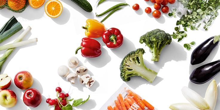 Assortiment van verse groenten en fruit, waaronder paprika's, broccoli, tomaten, appels, champignons en wortels.
