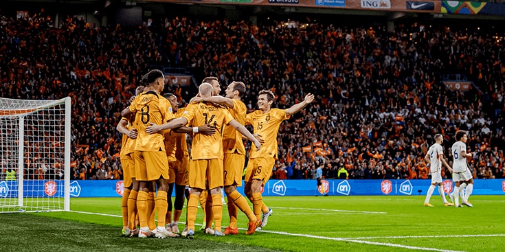 Voetbalteam van Nederland viert een doelpunt in een stadion vol met juichende supporters en zichtbaar Albert Heijn logo.