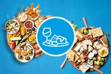 Borrelplanken met diverse hapjes, kazen en wijniconen op een blauwe achtergrond.