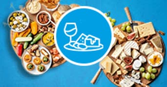 Borrelplanken met diverse hapjes, kazen en wijniconen op een blauwe achtergrond.