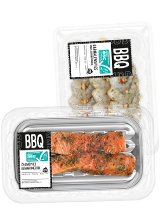 Twee barbecuepakketten: Marinatede Zalmspiesen en Gamba's ready to cook, verpakt in transparante plastic bakjes.