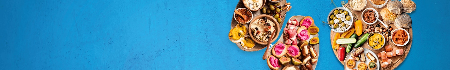 Diverse selectie van tapashapjes en dips op een blauwe ondergrond