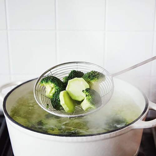 Broccoli wordt uit de pan gehaald na blancheren