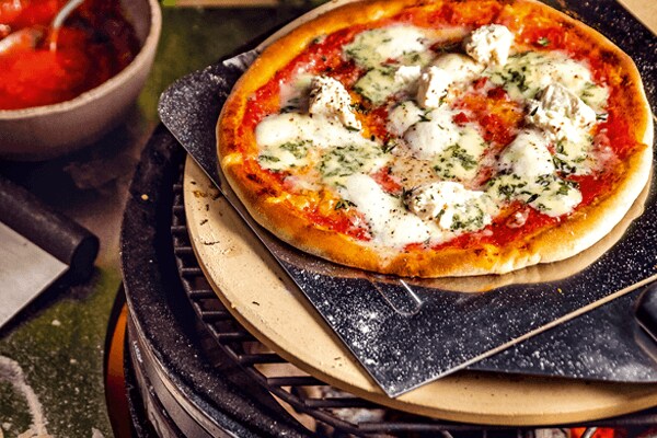 Pizza op pizzasteen op BBQ