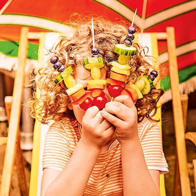 kindje met fruitstokjes