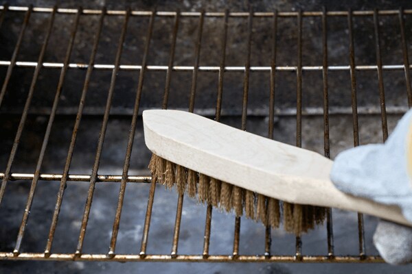 Met staalborstel roest verwijderen van BBQ-rooster