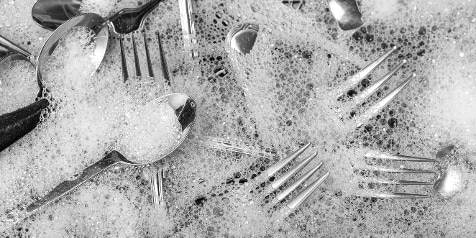 Bestek in zeepsop met schuim bubbels.