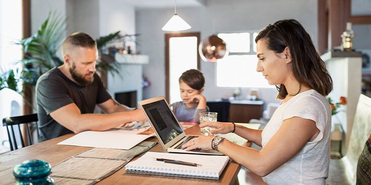 Gezin samen aan tafel met laptop en notitieboekje