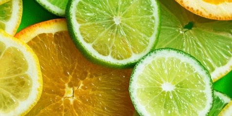 Plakjes citroen en sinaasappel op groene achtergrond