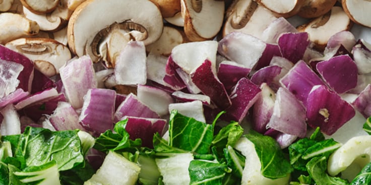 Gesneden champignons, rode uien en groene bladgroenten