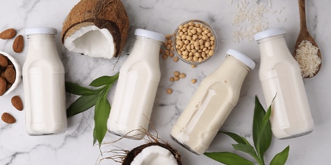 Flessen plantaardige melk met kokosnoot, amandelen, sojabonen en rijst.