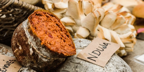 Nduja worst op een rustieke plank met brood op de achtergrond