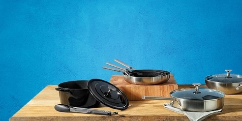 Kookpottenset op houten tafel met blauwe achtergrond