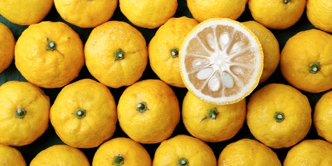 Yuzu-vruchten met één doorsneden helft tonen sappig vruchtvlees en zaden