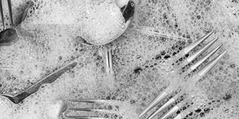 Bestek en schuim in een afwasteil