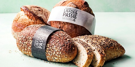 Broden van Liefde & Passie met zaden en gesneden meergranenbrood op een tafel.