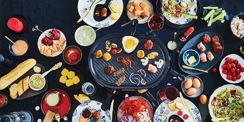 Gourmet maaltijd met diverse vleessoorten, groenten, sauzen en bijgerechten op een tafel.