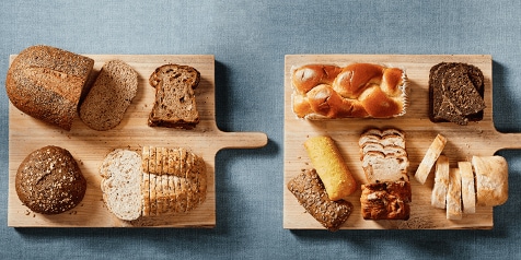 Verschillende soorten brood op houten snijplanken op een stoffen achtergrond.