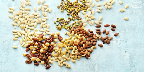 Verschillende soorten noten verspreid op een lichtblauwe achtergrond