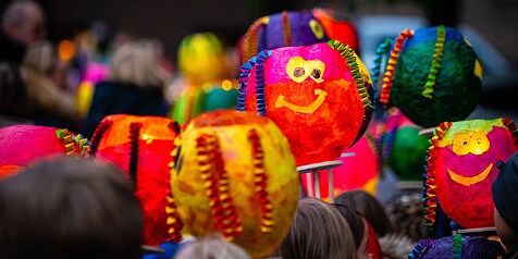 Gekleurde lampionnen met vrolijke gezichten tijdens een optocht