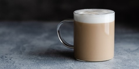 Glas met latte macchiato op een tafel