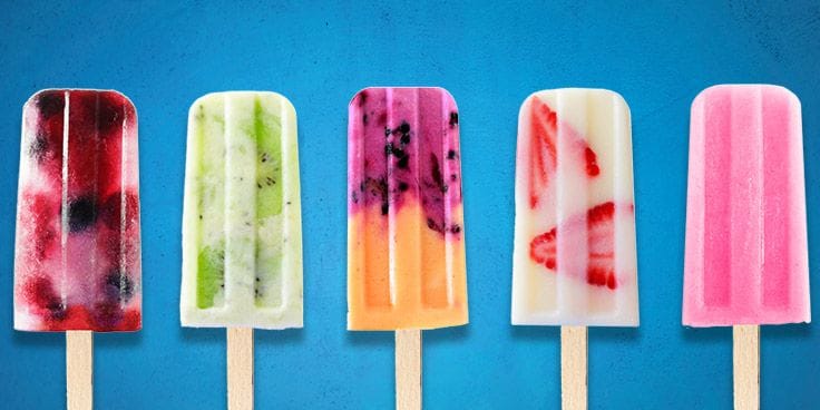 IJsjes met verschillende smaken en stukjes fruit op een blauwe achtergrond