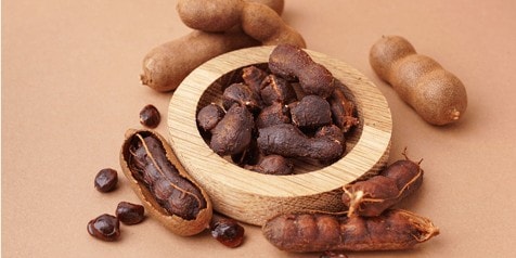 Tamarindepeulen en zaden op een bruine ondergrond