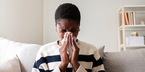 Persoon in gestreepte trui op bank in woonkamer