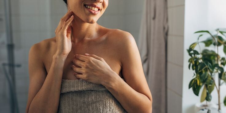 Vrouw in een handdoek in de badkamer