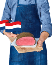 Slager in blauwe schort presenteert een stuk rosbief met Nederlandse vlag.