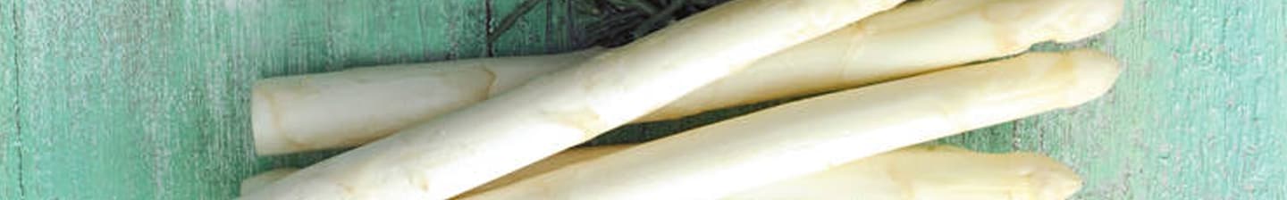 Witte asperges op een groene houten achtergrond