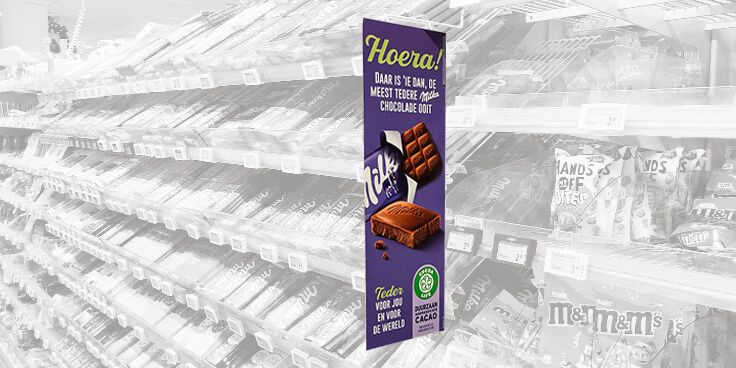 Reclamebord voor Milka-chocolade in een supermarktgang.
