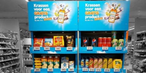 Promotieplank met snacks en dranken bij Albert Heijn met de tekst "Krassen voor een GRATIS product bij elke €15".