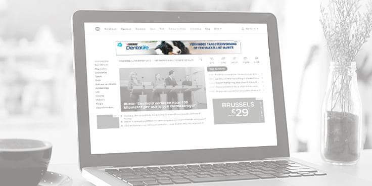 Laptop met internetbrowser geopend op een nieuwswebsite, inclusief advertenties op het scherm.