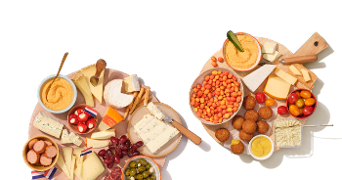 Borrelschalen met diverse kazen, druiven, olijven, humus en hapjes