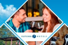 Twee mensen proosten met rode wijn bij Fletcher Hotels